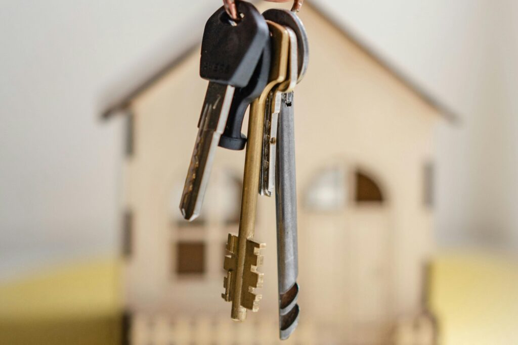 House keys and a house figurine in the concept of moving house.