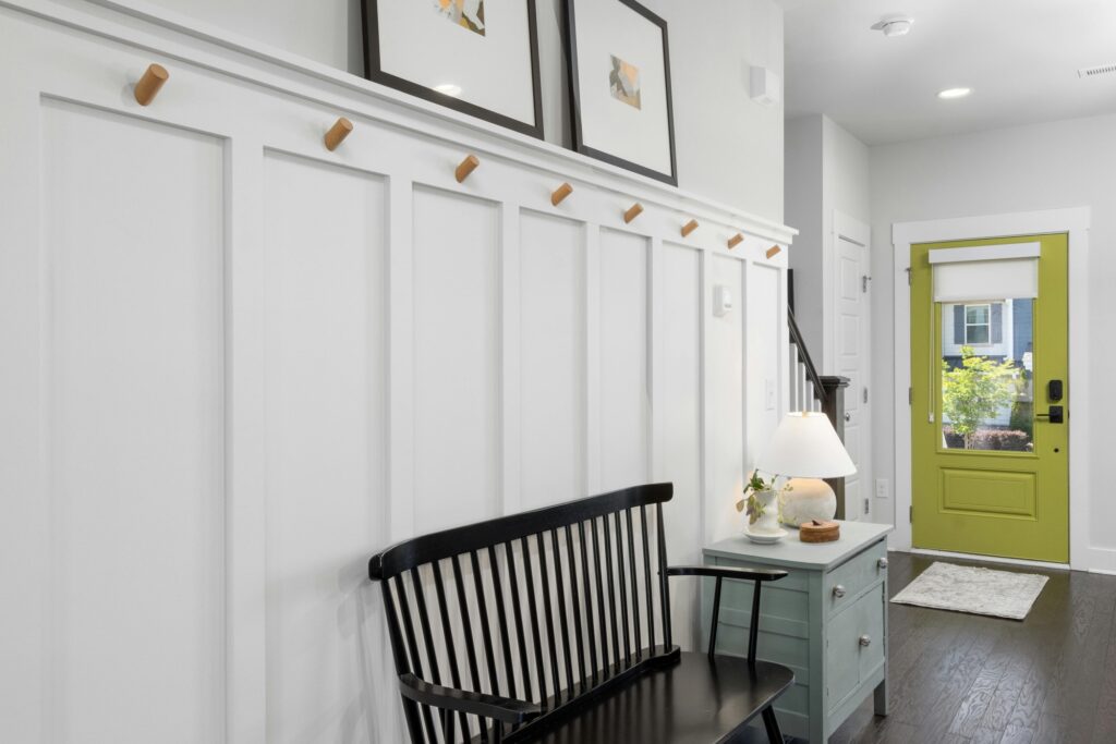 A white hall of an apartment with a green door