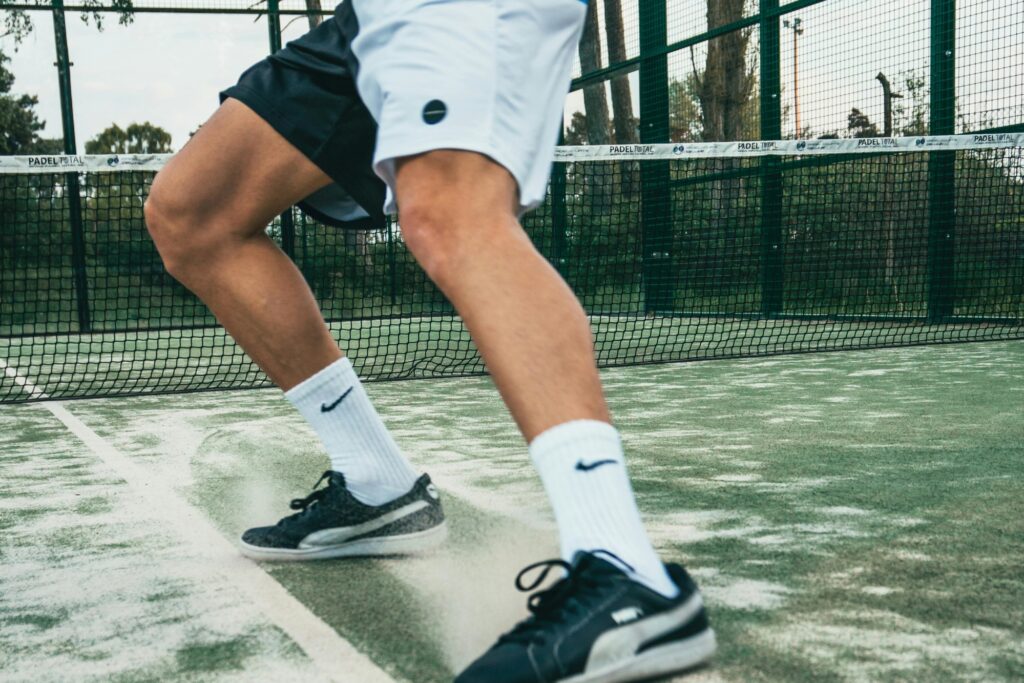 A man in the tennis court in the concept of parks and green spaces in Chiswick.