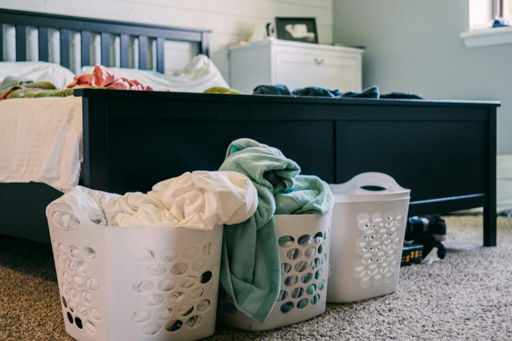 Clothes, towels, and baskets in the bedroom for sorting