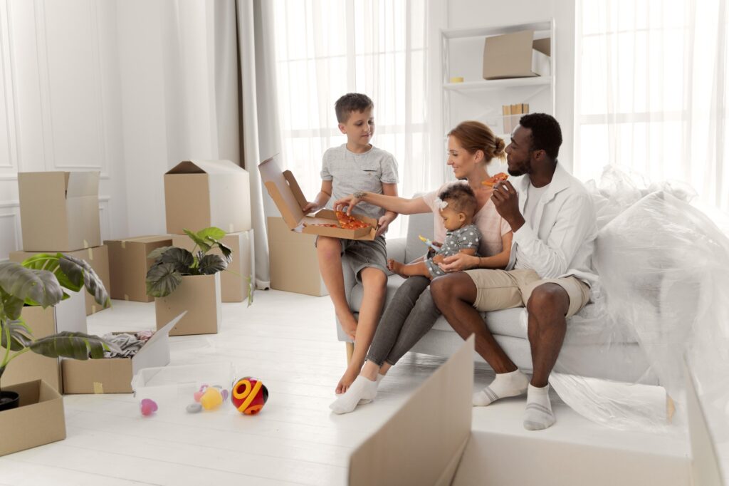 A young family taking a break after packing the living room in the concept of 'How to Pack Household Items Safely for a Move to Chiswick'.