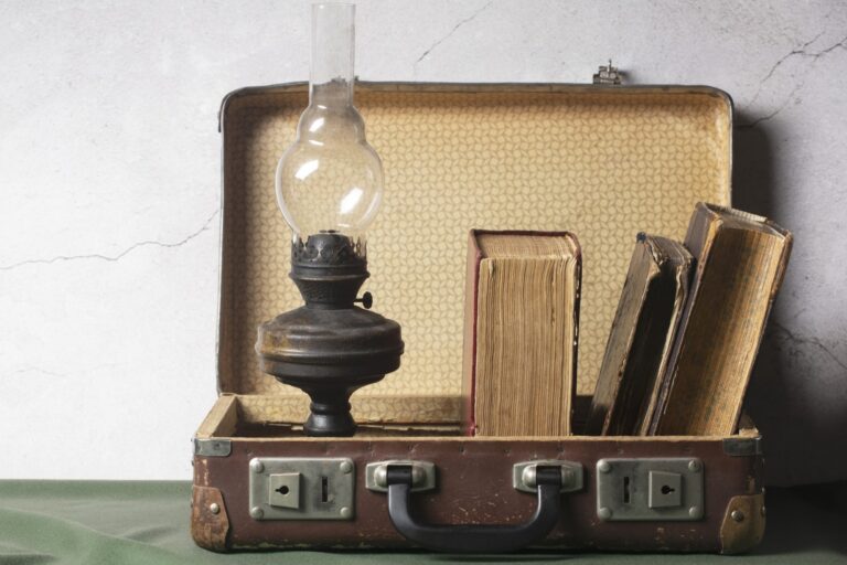 A vintage briefcase with books and lamp in the concept of 'How to Move Valuable and Fragile Items Safely When Moving House'.